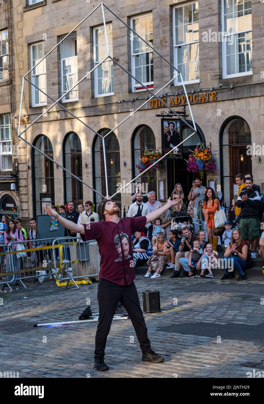 Edinburgh, Schottland, Großbritannien, 13.. August 2022. Edinburgh Fringe Unterhaltung: Ein Straßenkünstler unterhält die Menge mit einem Balanceakt Stockfoto