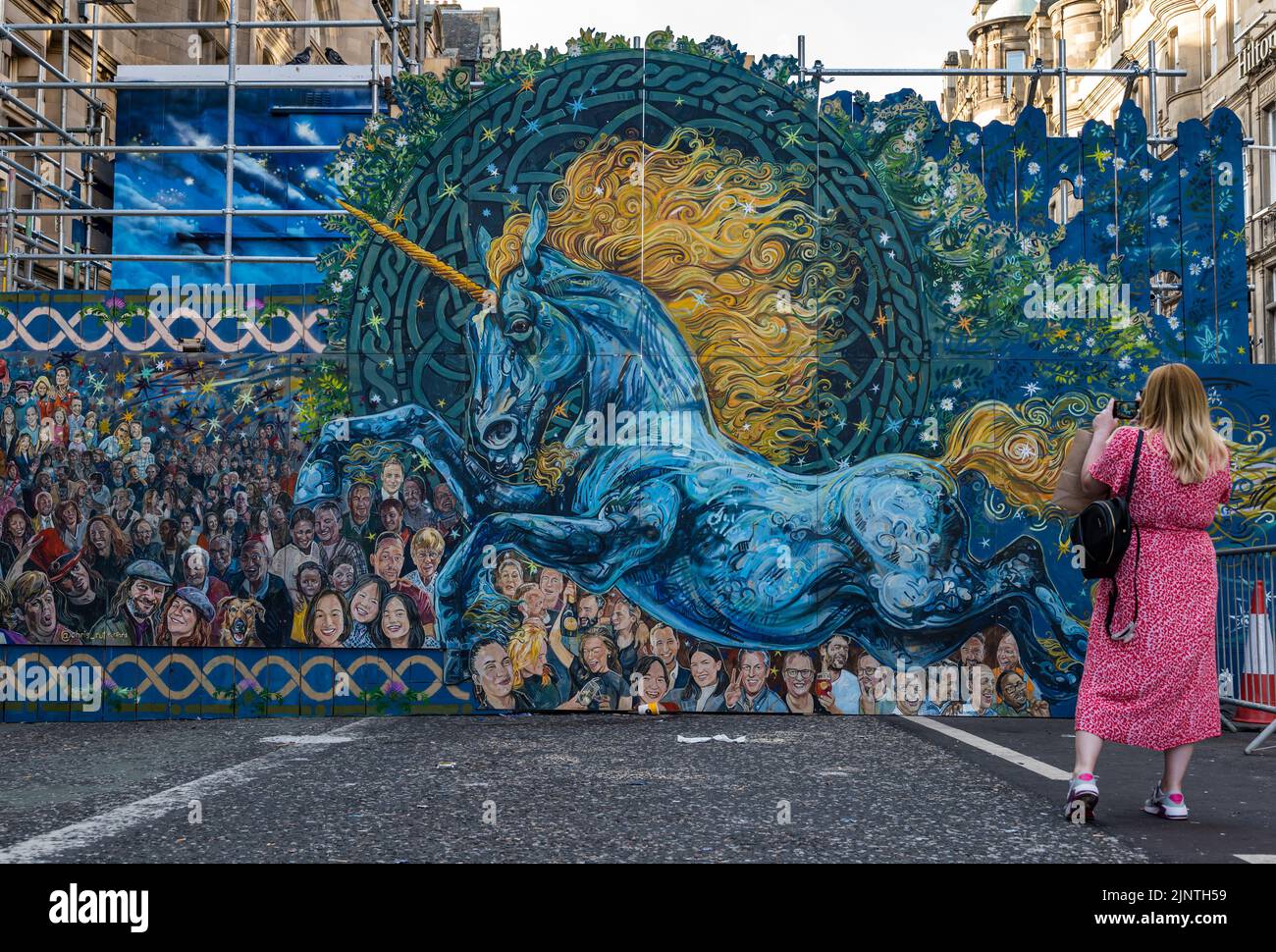 Edinburgh, Schottland, Großbritannien, 13.. August 2022. Neue Street Art von Chris Rutterford: Hortarbeiten an den Straßenarbeiten auf der North Bridge wurden mit großen Tafeln bedeckt, die der Künstler gemalt hat, um den Passanten mit der längeren Schließung für Brückenreparaturen etwas leichtes Relief zu bringen. Die Gemälde zeigen echte Menschen Stockfoto