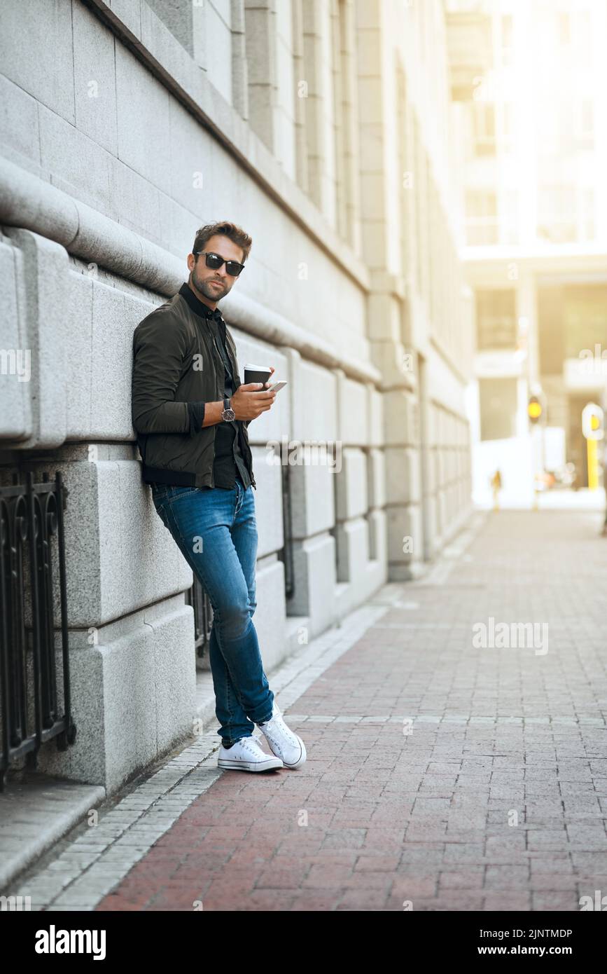 Das Leben in der Großstadt. In voller Länge ein hübscher junger Mann, der einen Text sendet, während er durch die Stadt reist. Stockfoto