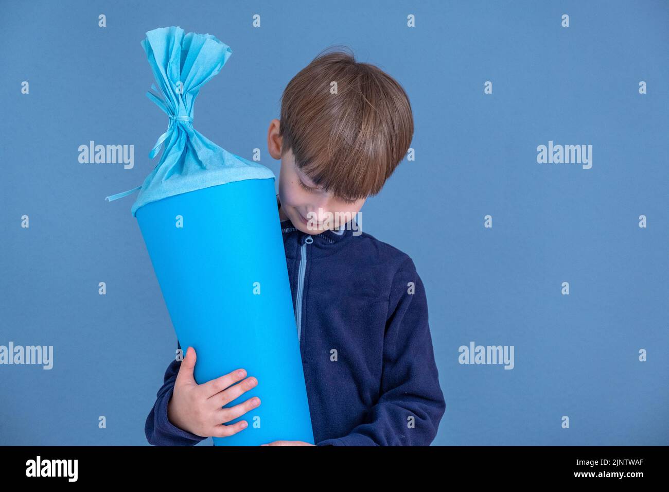 Kind hält am ersten Schultag traditionellen deutschen Süßigkeitenkegel. Junge mit einer süßen Tasche. Schulbeginn in Deutschland Stockfoto