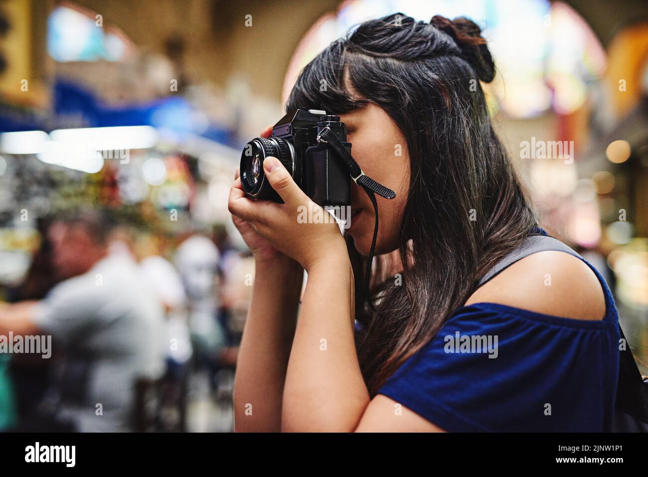 Ich möchte Fotos von diesem Markt machen. Eine unbeschwerte junge Frau, die tagsüber Fotos von einem Lebensmittelmarkt fotografiert. Stockfoto