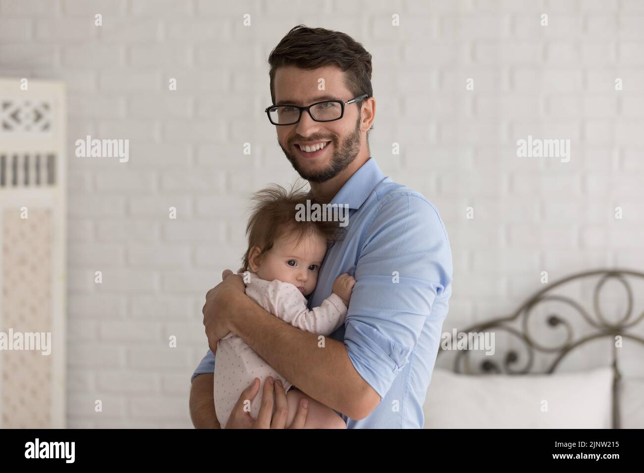 Porträt des glücklichen Vaters kuschelt hält auf den Armen neugeborene Tochter Stockfoto