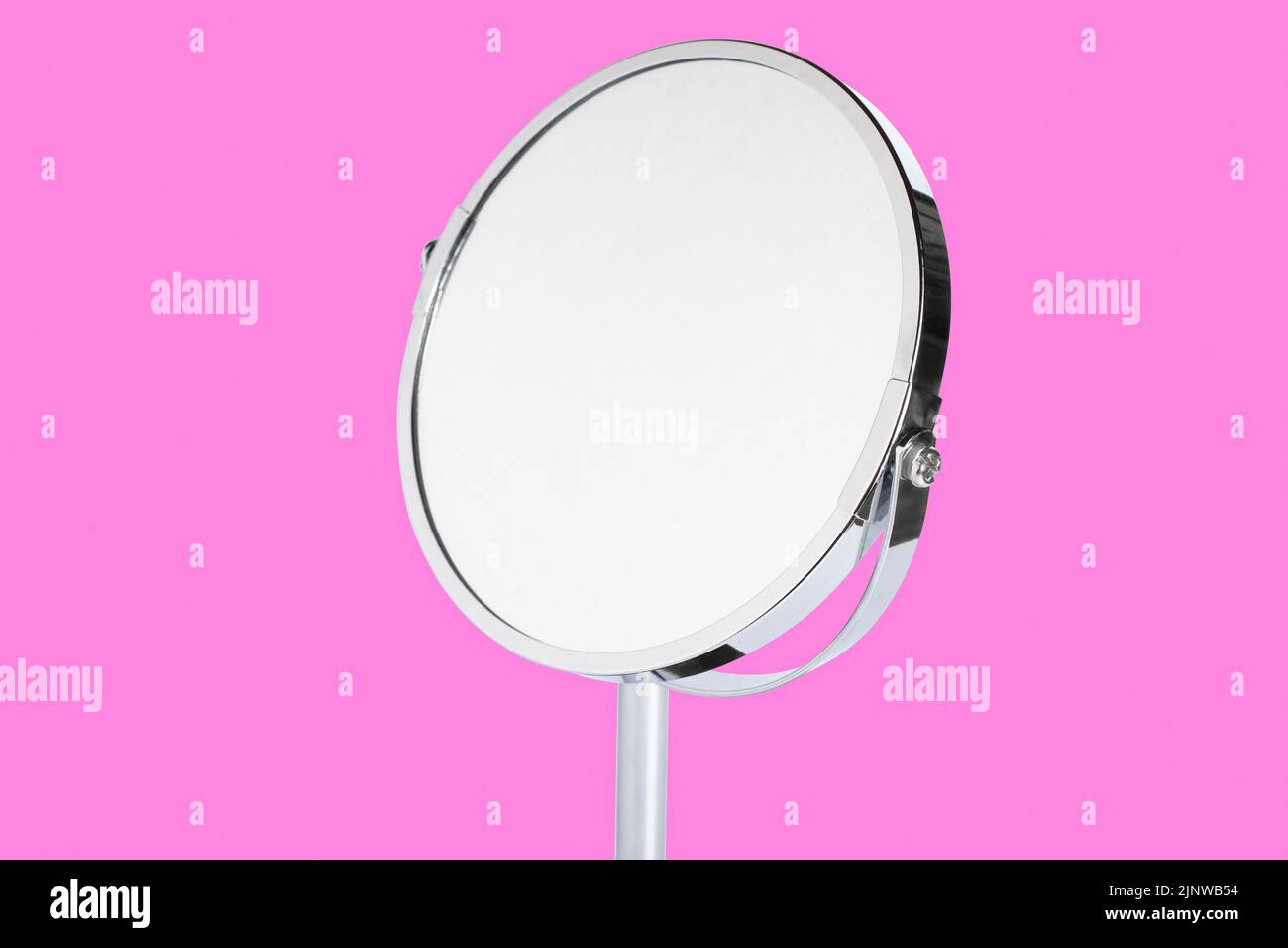 Desktop Make-up Kosmetikspiegel isoliert auf rosa Hintergrund. Home Metallspiegel Nahaufnahme isoliert. Gesichtsspiegel Stockfoto