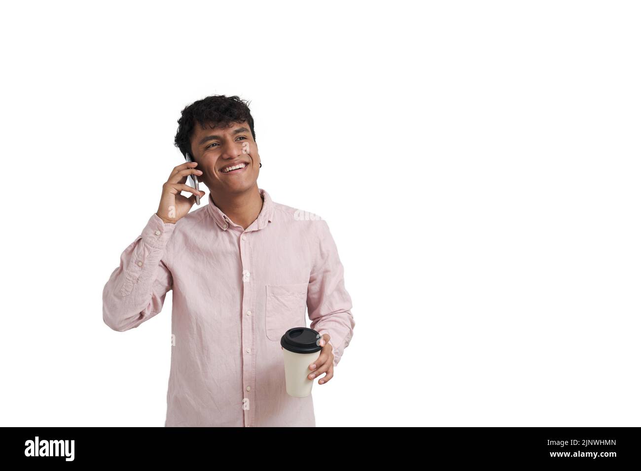 Junger peruanischer Mann lächelt und telefoniert mit einer Kaffeetasse, isoliert. Stockfoto