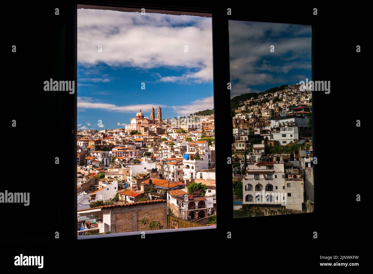 Durch das Fenster in Taxco de Alarcón, Guerrero, Mexiko, wird ein historisches Zentrum mit konservierter Kolonialarchitektur gesehen. Stockfoto