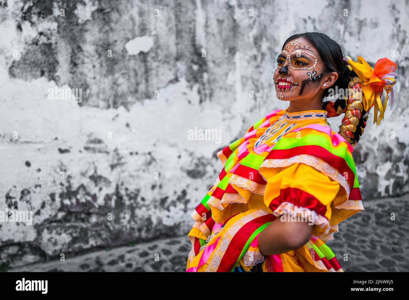 Ein mexikanisches Mädchen, bekleidet als La Catrina, tanzt während der Feierlichkeiten zum Tag der Toten in Taxco, Mexiko. Stockfoto