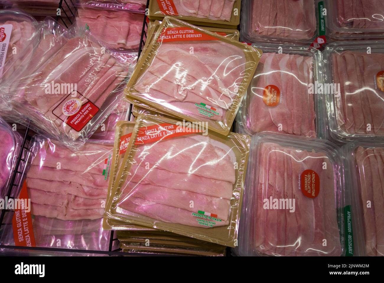 Fossano, Italien - 11. August 2022: Packungen mit glutenfreien gekochten Schinkenscheiben in der Kühltheke des italienischen Supermarkts. Tex:senza glutine senza l Stockfoto