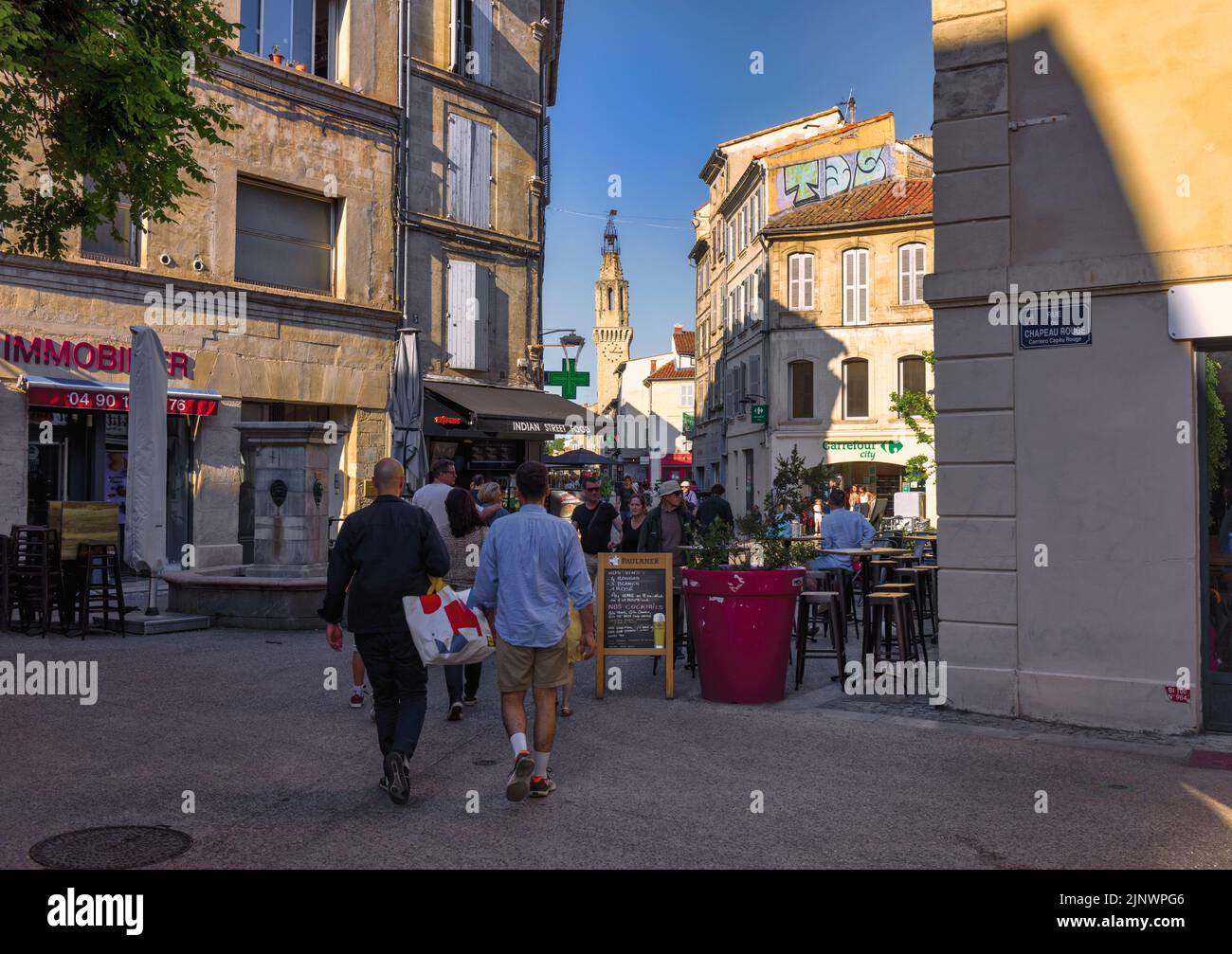 Typische Straßenszene. Glockenturm des Couvent des Augustins, des Augustinerklosters, im Hintergrund. Avignon, Vaucluse, Frankreich. Stockfoto