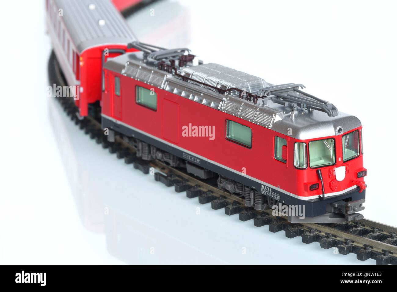 Maßstab Spielzeug Modell der roten Zug isoliert auf weiß reflektierenden Hintergrund Stockfoto