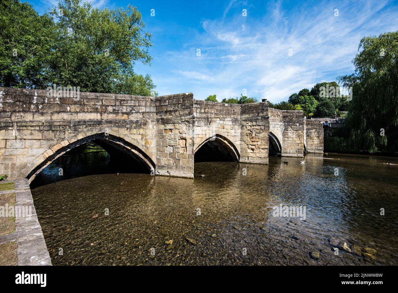Bakewell Bridge ist eine denkmalgeschützte Steinbogenbrücke über den Fluss Wye in Bakewell, Derbyshire. Die Brücke ist auch ein geplantes Denkmal. Stockfoto