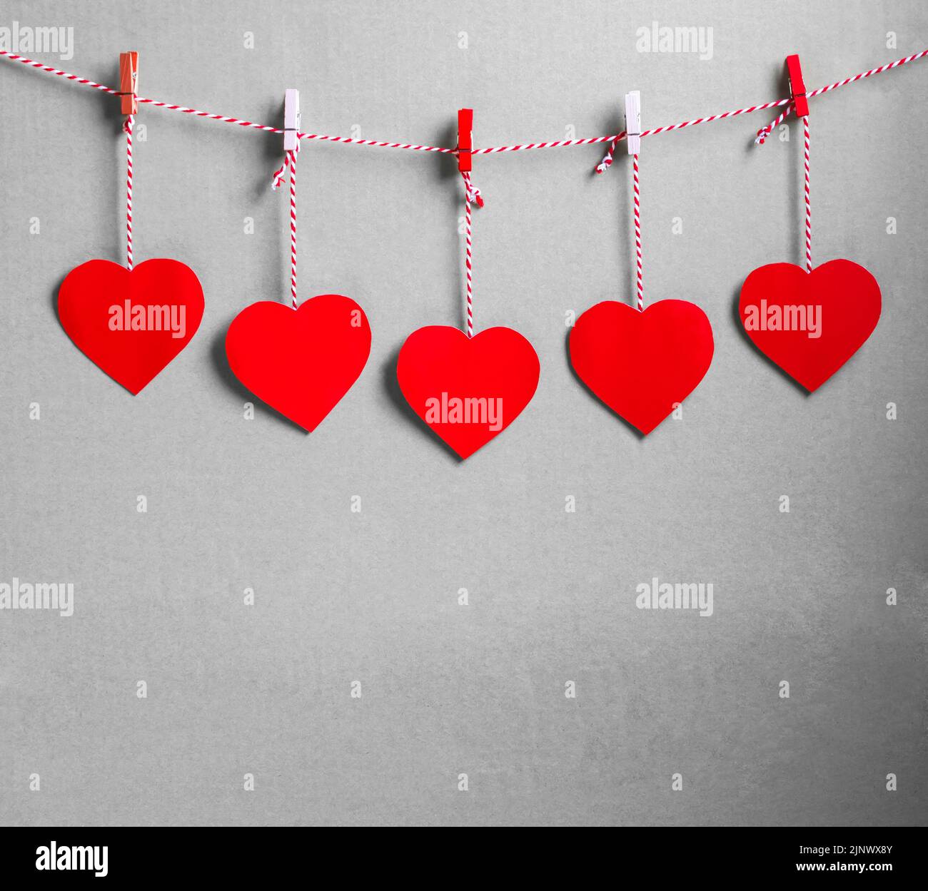 Rotes Herz Papier geschnitten mit natürlicher Kordel und roten Clips an der Wand hängen, Kopierraum, Valentinstag - Bild Stockfoto