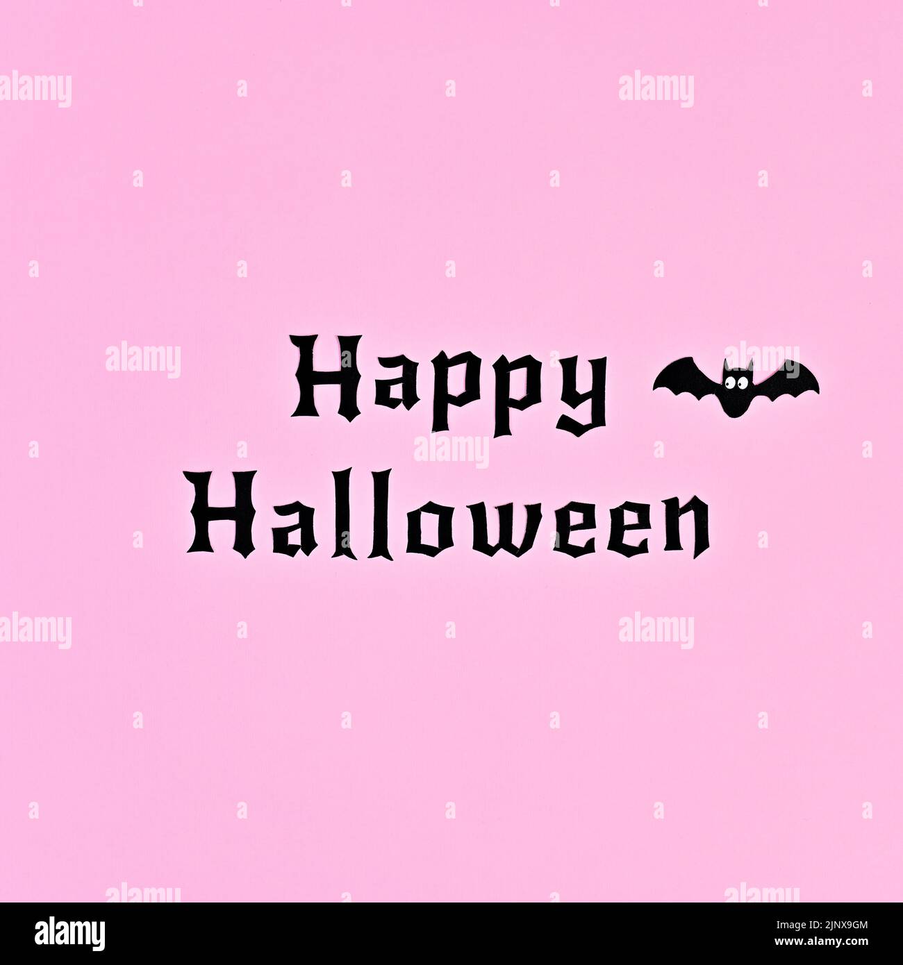 Einfache minimal Happy Halloween Hintergrund mit Fledermaus auf pastellrosa Hintergrund. Flach liegend Stockfoto