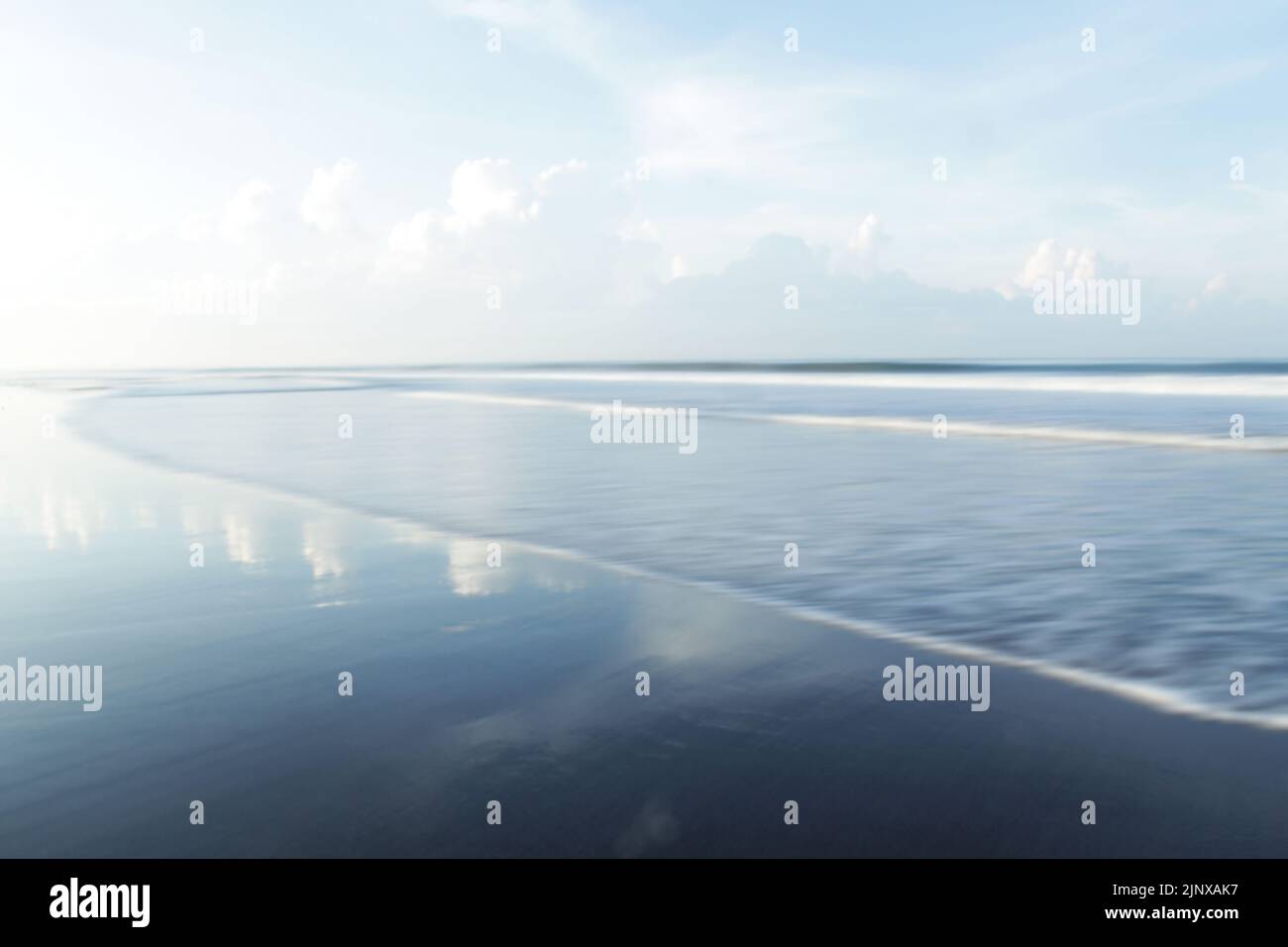 Blau verwackelte Strand Hintergrund. Verschwommener blauer Himmel, Meer und Wellenwasser natürliche Muster Hintergründe. Ein sanfter blauer Himmel über dem Horizont ist inspirierend. Stockfoto