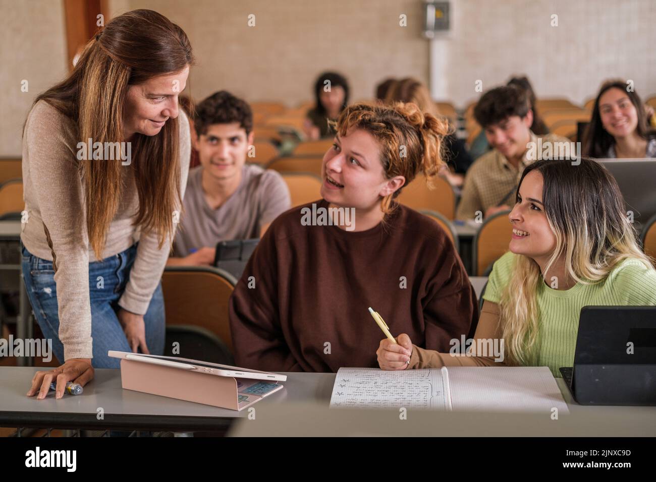 Der Lehrer löst die Zweifel einzeln an der ersten Reihe der Klasse auf dem Tablet Stockfoto