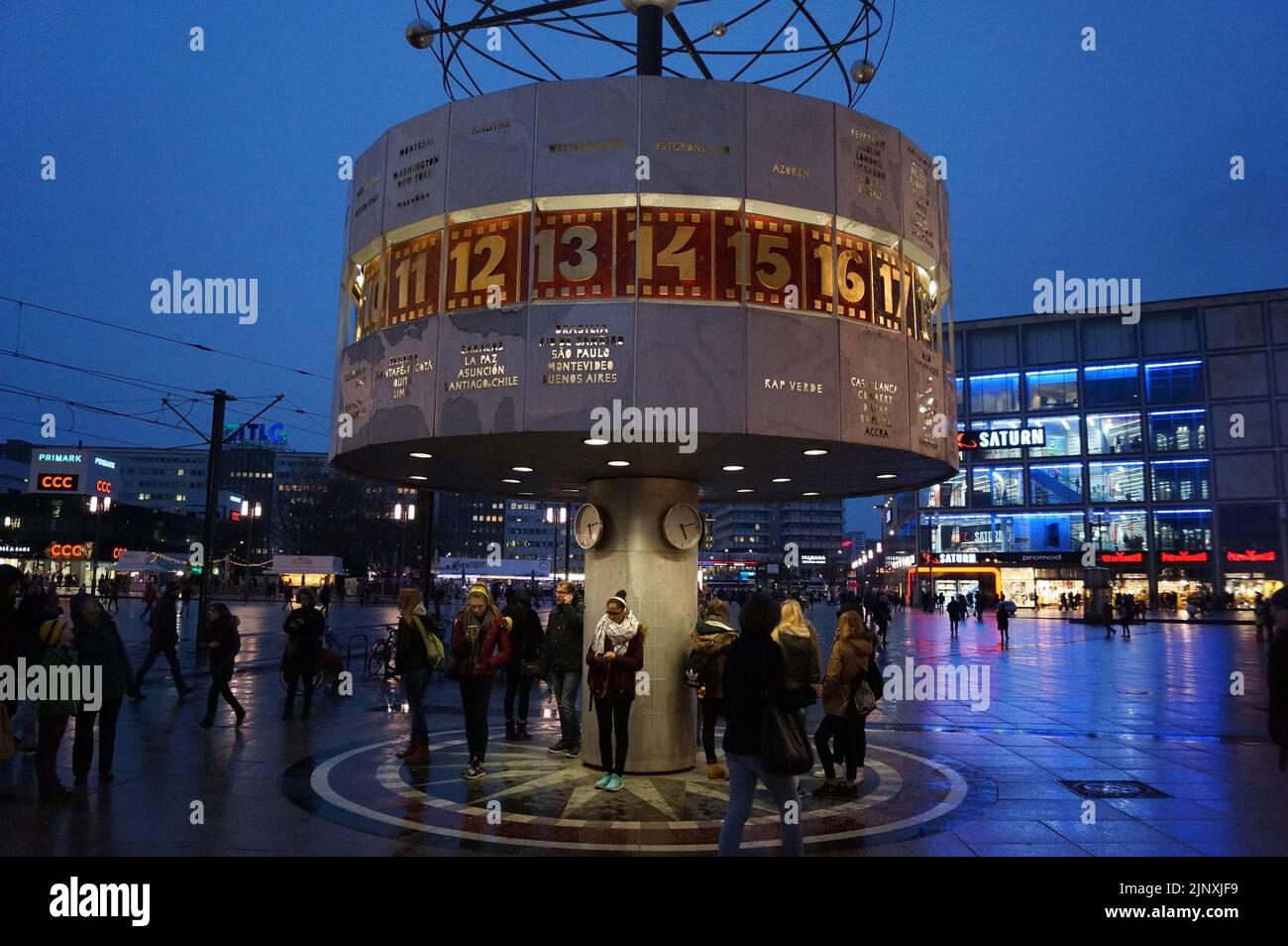 Berlin, Deutschland: Menschen versammelten sich um die Urania-Weltuhr auf dem Alexanderplatz, bei Nacht Stockfoto