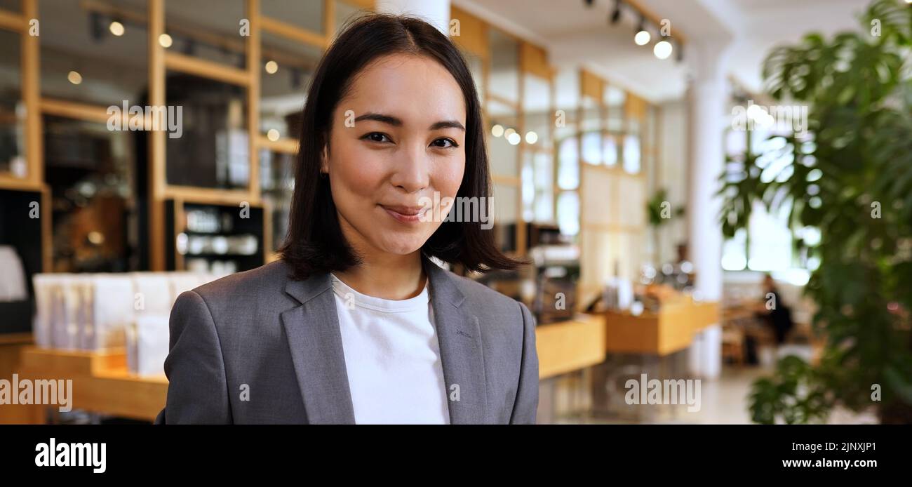 Lächelnde junge asiatische professionelle Frau trägt Anzug, Porträt, Banner Stockfoto