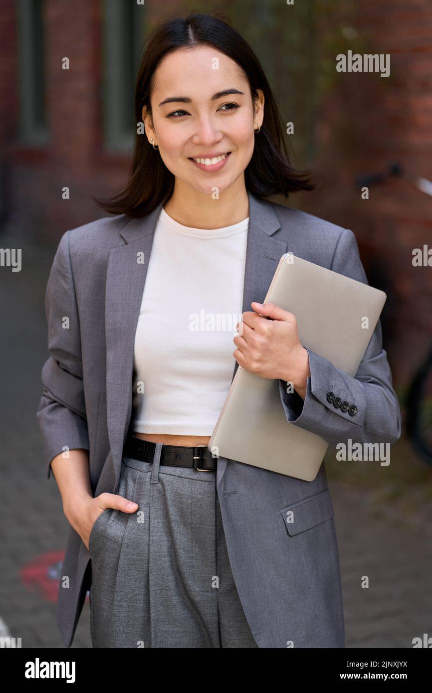 Junge stilvolle asiatische Geschäftsfrau Führer hält Tablet, Outdoor-Porträt. Stockfoto