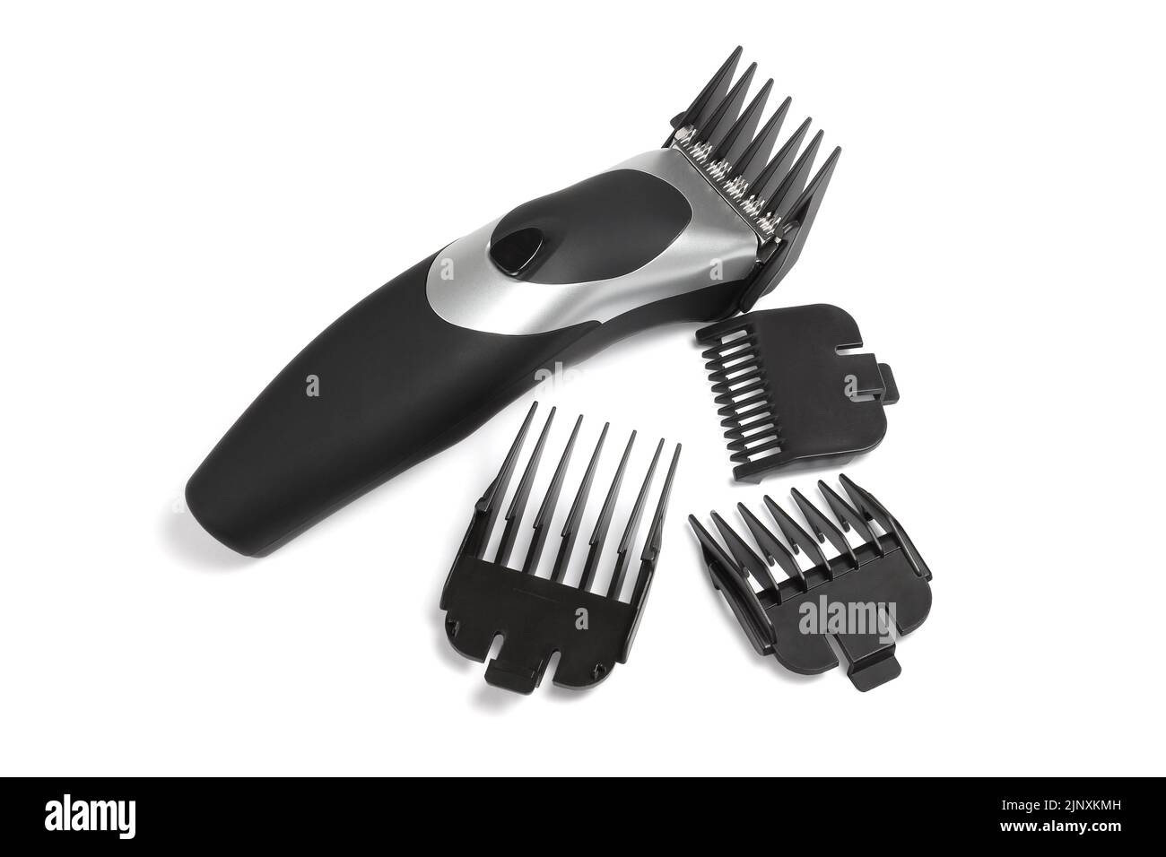 Elektrischer Haarschneider und verschiedene Kunststoffkämme auf weißem Hintergrund Stockfoto