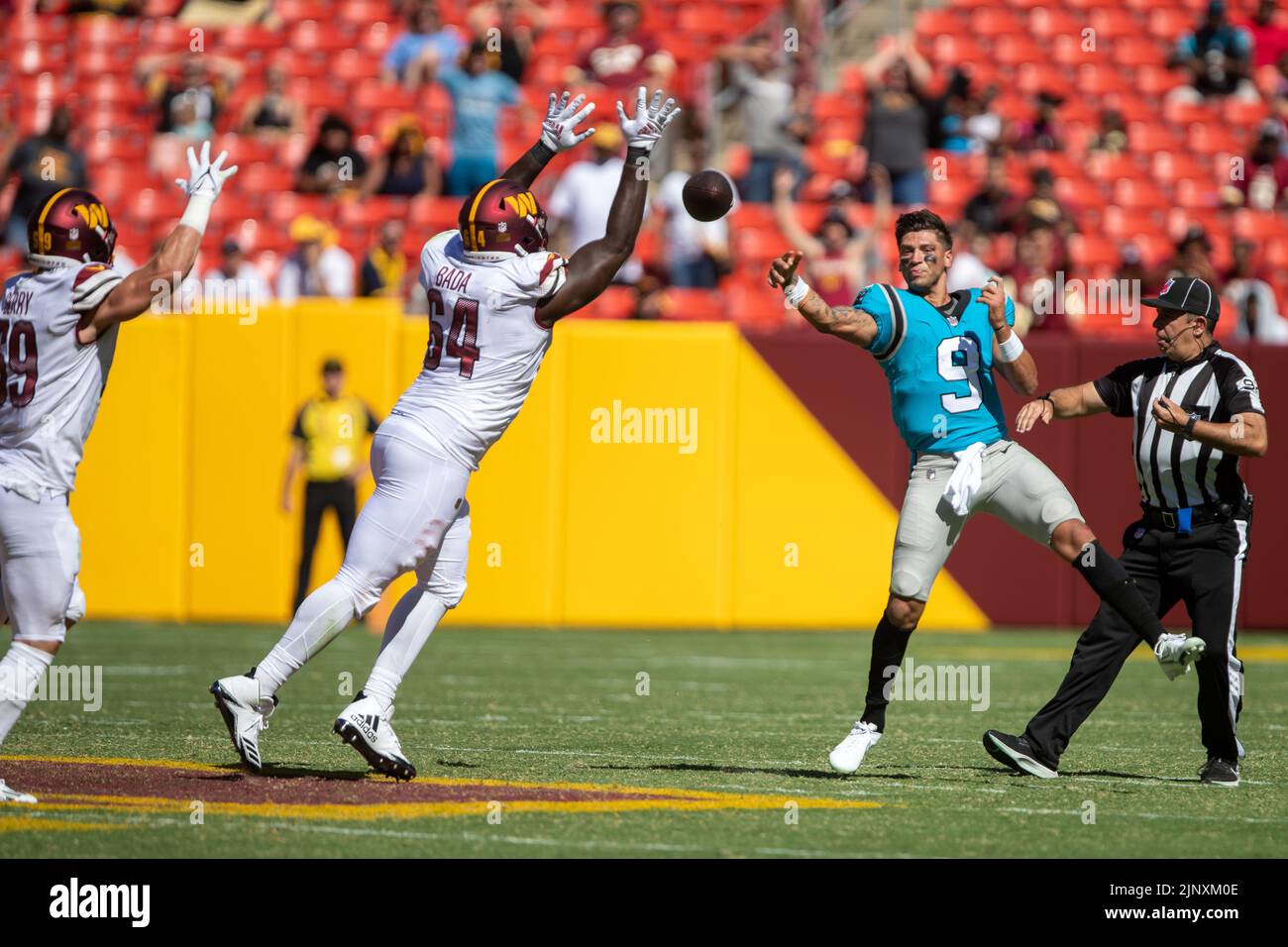 David Bada (64) verfolgt den Carolina Panthers Quarterback Matt Corral (9), nachdem sein Helm während des NFL Preseason-Spiels zwischen den Carolina Panthers gegen die Washington Commanders am 13. August 2022 im FedEx Field in Landover, MD, abgehoben wurde. Die Panther besiegten die Commanders mit 23:21. Nachdem ein Spieler seinen Helm verloren hatte, nannte der Schiedsrichter das Stück tot. (Max Siker / Bild von Sport) Stockfoto