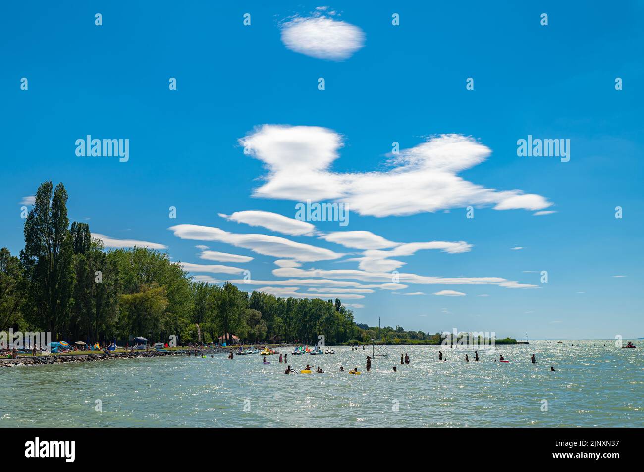 Linsenwolken (lateinischer Name: Altocumulus lenticularis) über einem Touristenort. Stockfoto