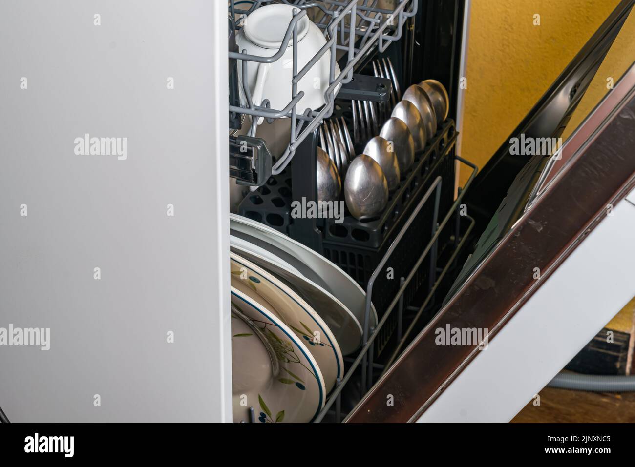 Nahaufnahme von schmutzigem Geschirr und anderen Küchenutensilien in der Spülmaschine vor dem Waschen. Stockfoto