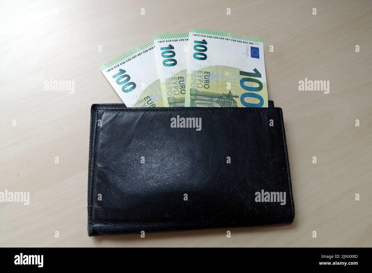 Symbolfoto: Hilfspaket in Deutschland für steigende Energiekosten: Dreihundert-Euro-Scheine sehen aus einer braunen Brieftasche Stockfoto