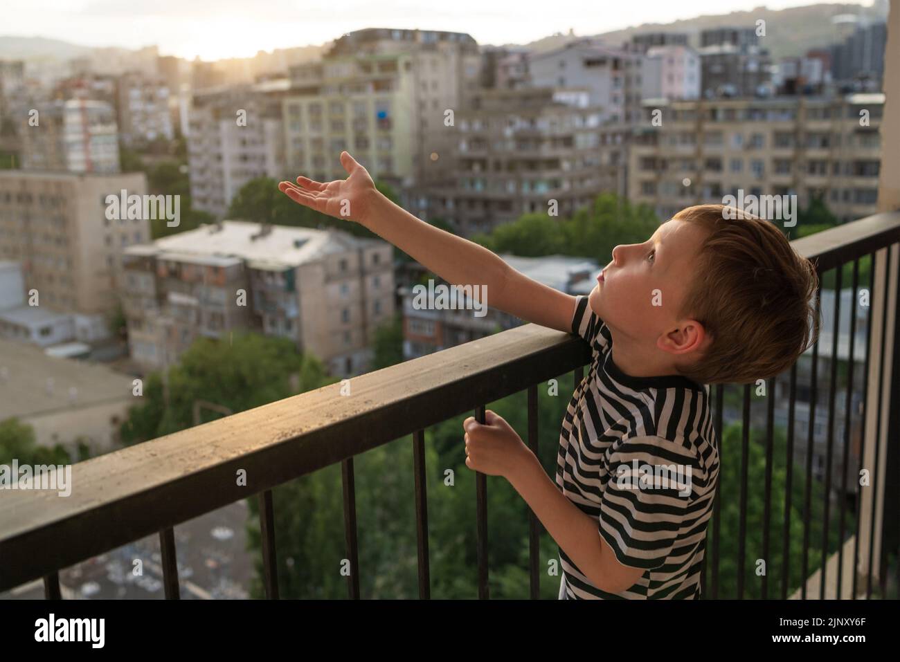 Unbeaufsichtigtes Kleinkind klettert gefährliches Balkongeländer riskantes Kinderverhalten Stockfoto