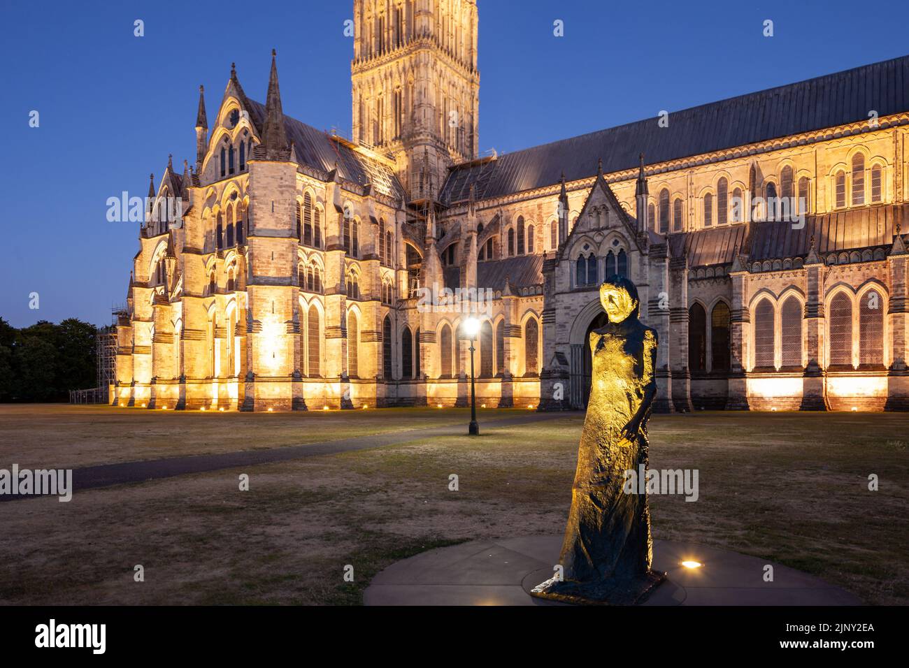 Walking Madonna Statue vor der Salisbury Cathedral an einem Sommerabend, Wiltshire, England. Stockfoto