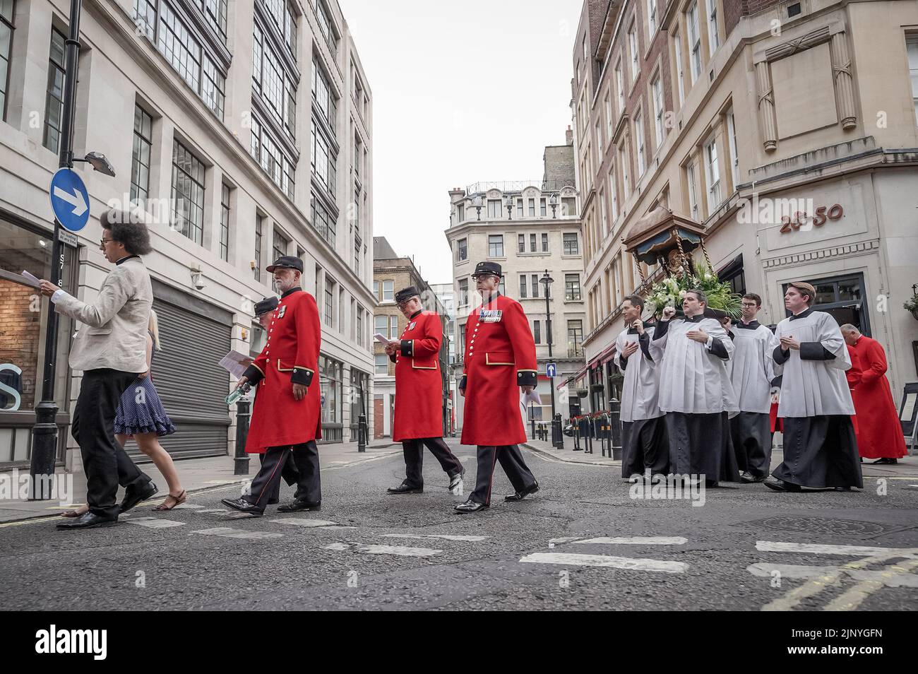 London, Großbritannien. 14.. August 2022. Calvin Robinson (links), der anglikanische Diakon und der Sender kommen mit den Chelsea Rentners zusammen, während der Mariä-Himmelfahrt-Prozession von der All Saints Margaret Street-Gemeinde entlang der Oxford Street. Das Fest der Himmelfahrt markiert den Anlass für den körperlichen Aufstieg der Jungfrau Maria in den Himmel am Ende ihres Lebens. Kredit: Guy Corbishley/Alamy Live Nachrichten Stockfoto