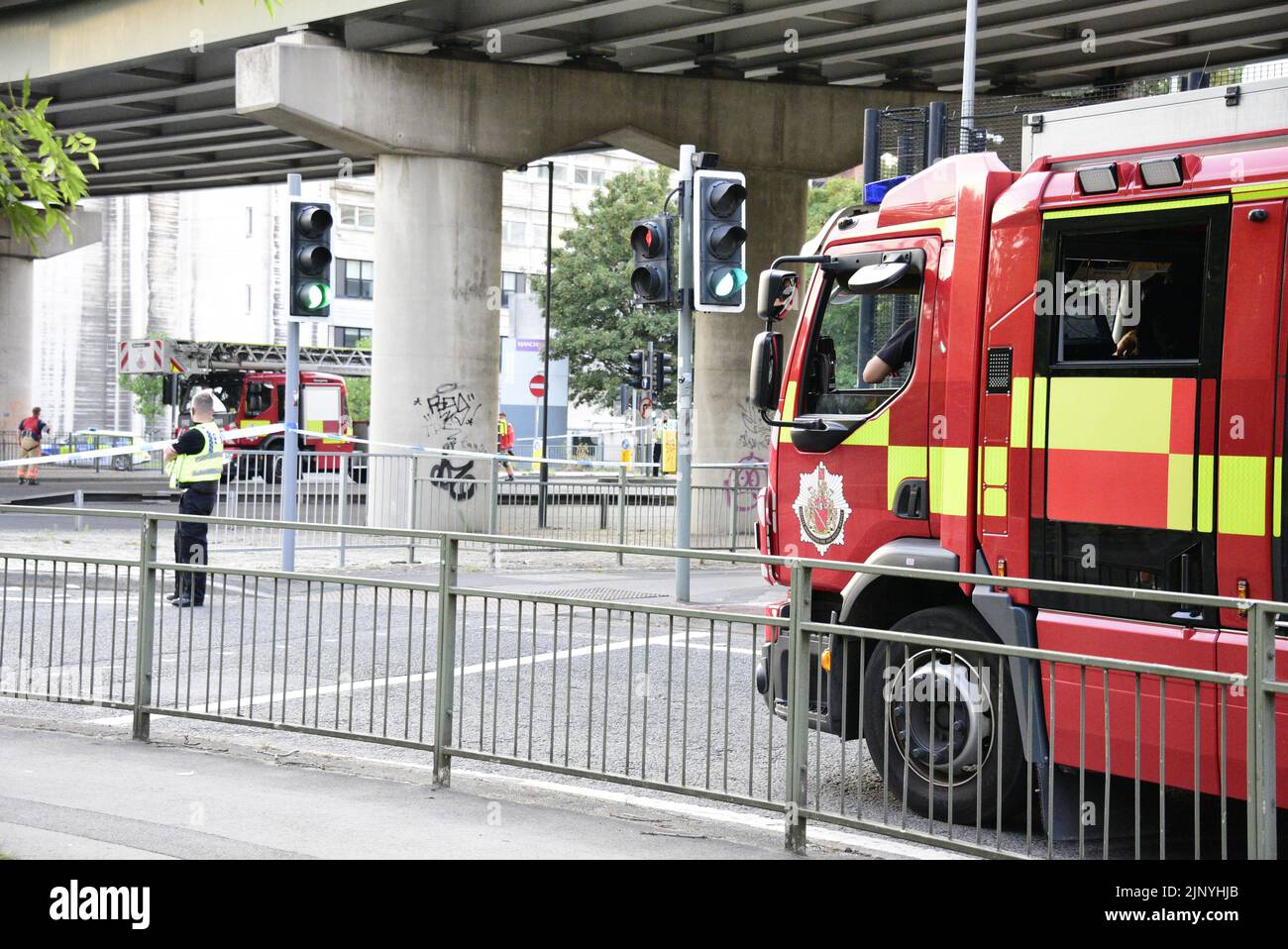 Manchester, Großbritannien, 14.. August 2022. Die Feuerwehr und Rettung von Greater Manchester kommen an, um zu helfen. Ein kaukasischer Mann scheint sich am Rande der Brücke des Mancunischen Weges zu befinden, manchmal am äußeren Rand, viele Meter über der Straße, und spricht mit Polizeibeamten. Feuerwehrfahrzeuge, ein Krankenwagen und etwa 5 Polizeifahrzeuge sind vorhanden. Der Mancunian Way und die London Road sind geschlossen und der Verkehr umgeleitet. Um 20,45 Uhr wurde die Polizeiwache aufgehoben und ein Zeuge sagte, dass der betreffende Mann in Sicherheit sei. Quelle: Terry Waller/Alamy Live News Stockfoto