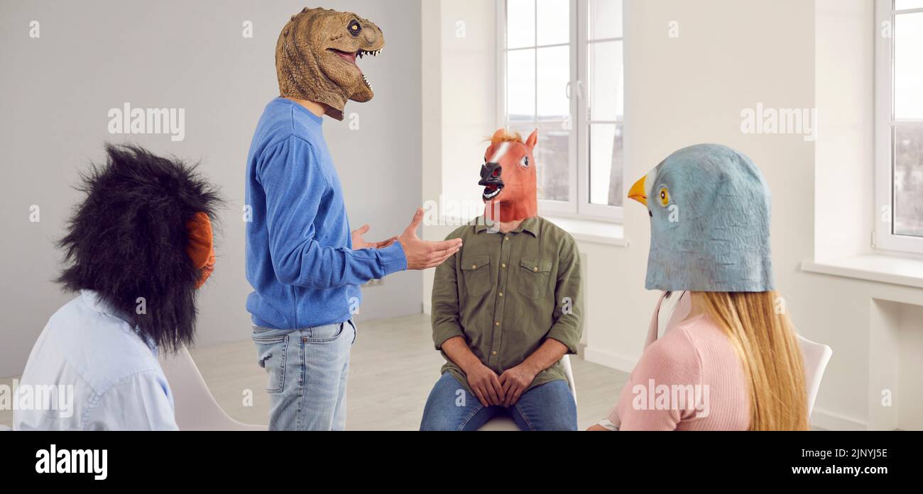 Ein Team von Leuten, die lustige verrückte Tiermasken tragen, reden während ihres Treffens im Büro Stockfoto