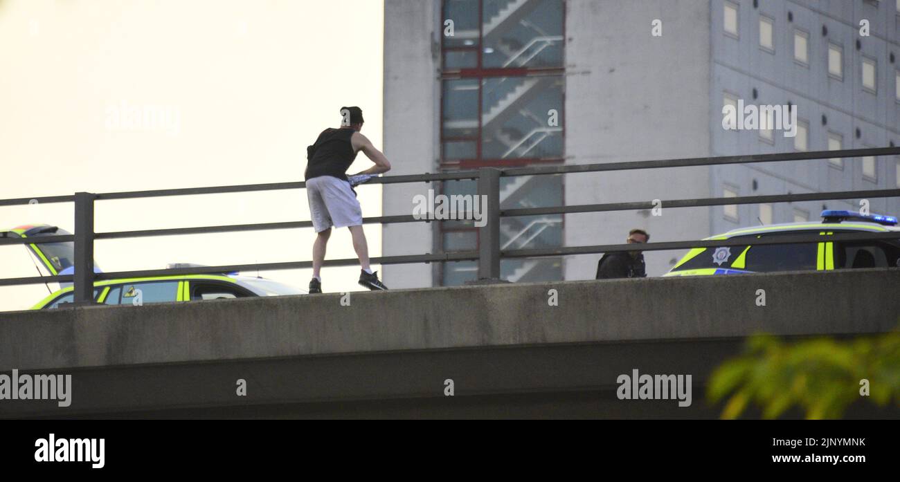 Manchester, Großbritannien, 14.. August 2022. Die Polizei hat am Sonntagabend eine große Absperrung um den Mancunian Way und die London Road Junction, in der Nähe des Stadtzentrums von Manchester, gelegt. Ein kaukasischer Mann scheint sich am Rande der Brücke des Mancunischen Weges zu befinden, manchmal am äußeren Rand, viele Meter über der Straße, und spricht mit Polizeibeamten. Feuerwehrfahrzeuge, ein Krankenwagen und etwa 5 Polizeifahrzeuge sind vorhanden. Der Mancunian Way und die London Road sind geschlossen und der Verkehr umgeleitet. Um 20,45 Uhr wurde die Polizeiwache aufgehoben und ein Zeuge sagte, dass der betreffende Mann in Sicherheit sei. Quelle: Terry Waller/Alamy Live News Stockfoto