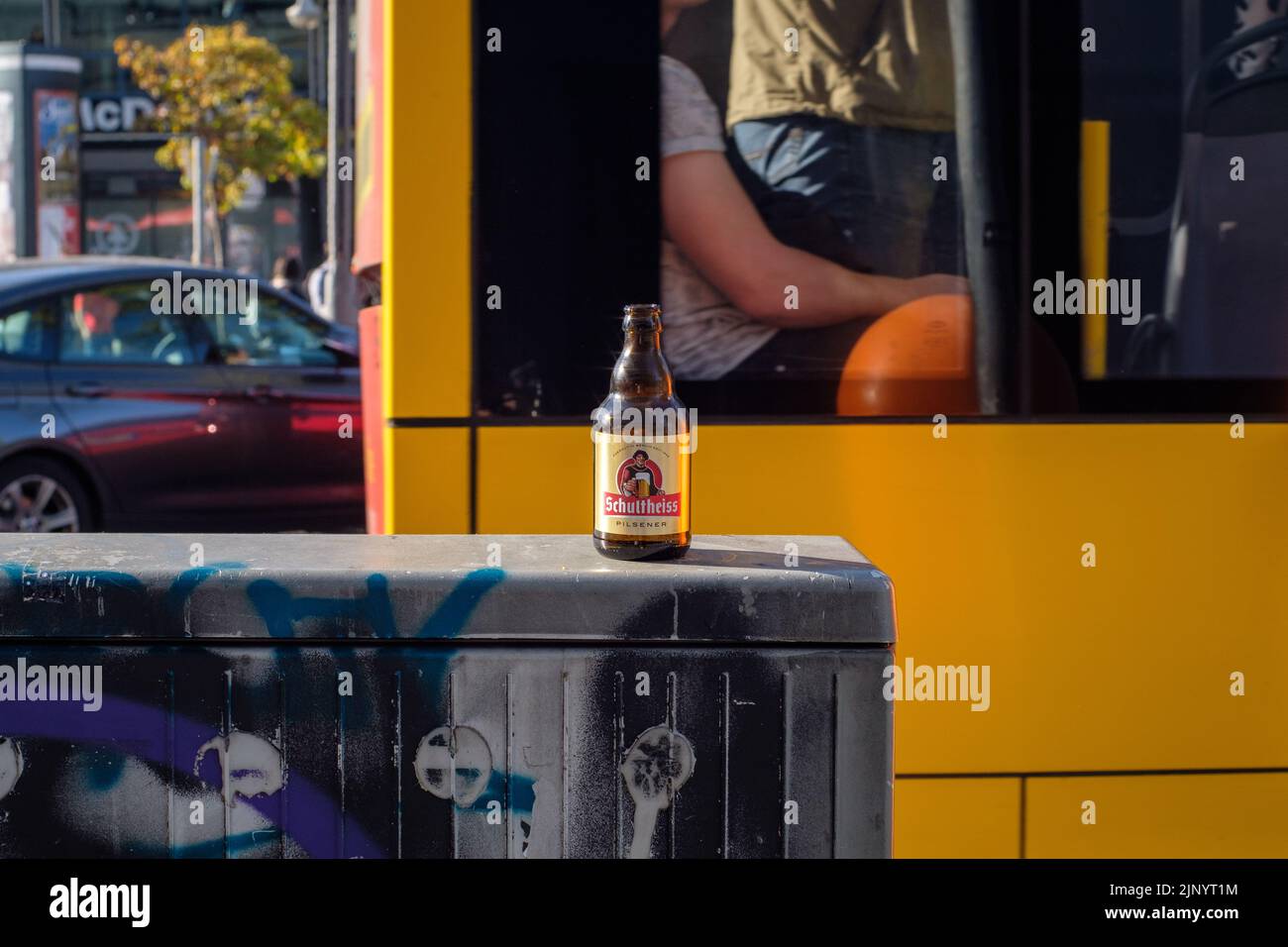 Eine verlassene leere Flasche Schultheiss-Bier in seinem natürlichen Lebensraum in den belebten Straßen Berlins. Stockfoto