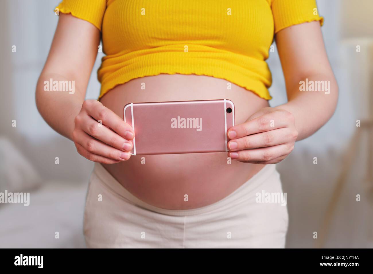 Aufnahme von Videos und Fotos am Telefon in den Händen einer Schwangeren Stockfoto