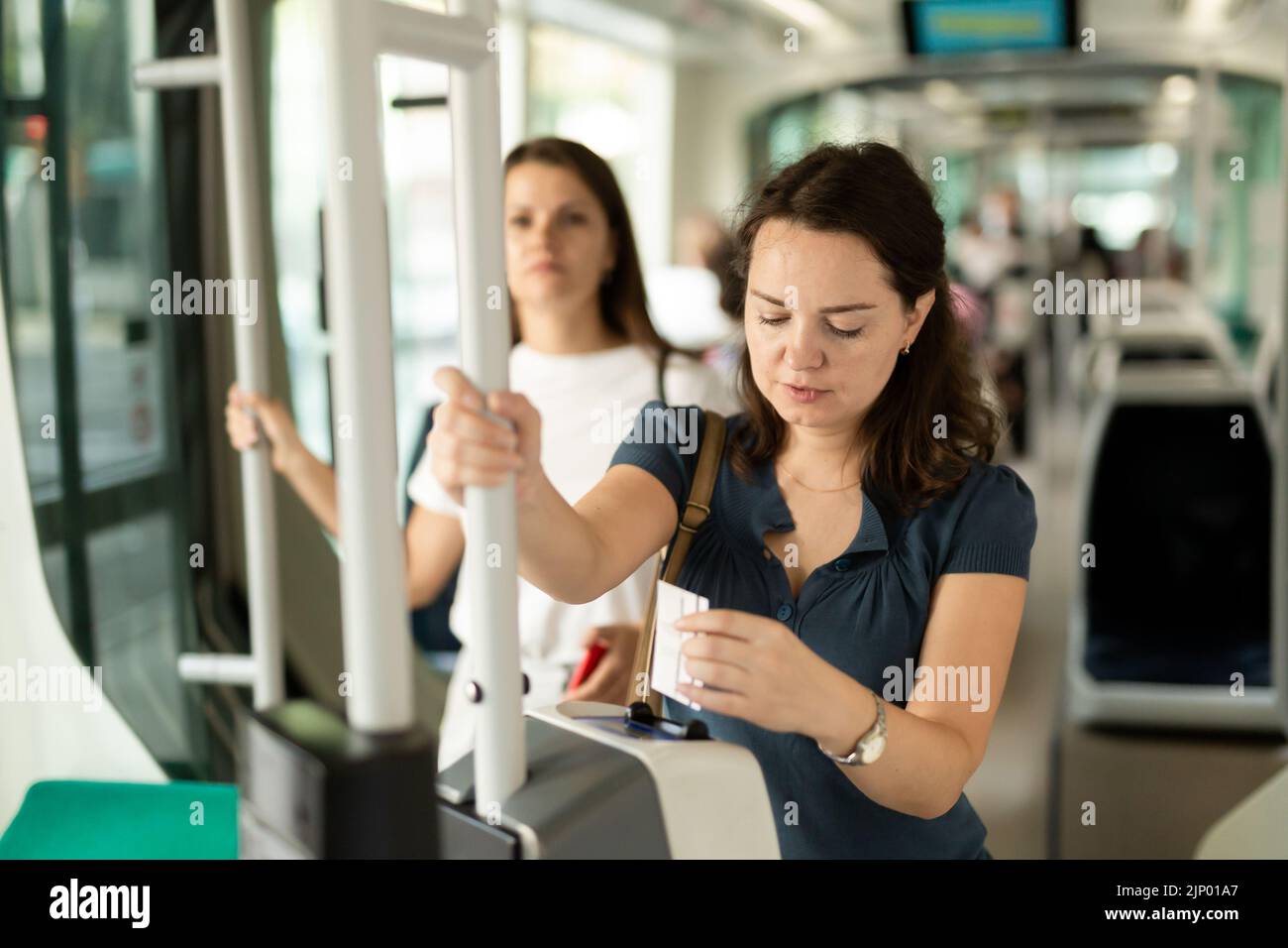 Frau, die das Ticket in öffentlichen Verkehrsmitteln auswertet Stockfoto