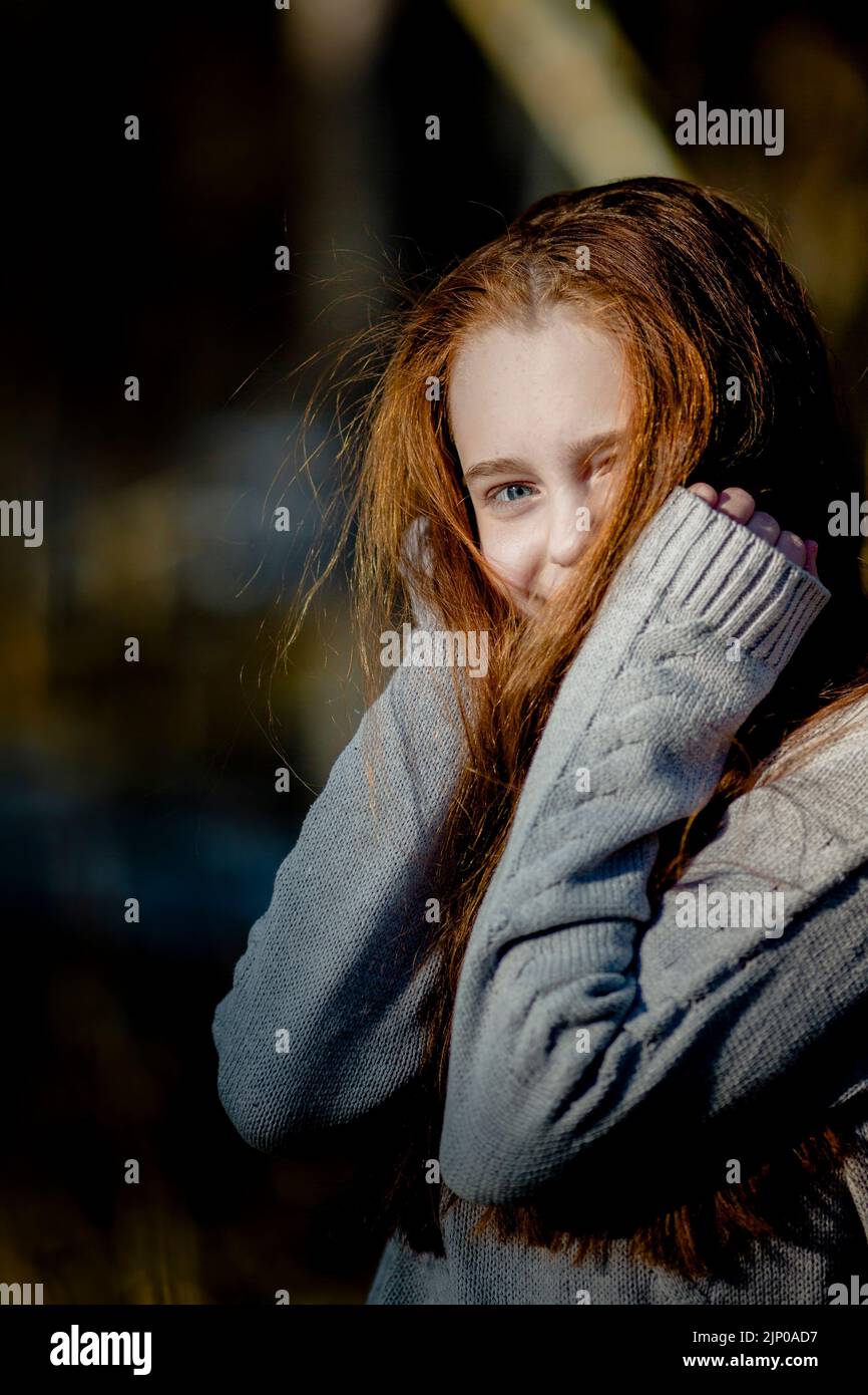 Ein goldhaariges Teenager-Mädchen posiert im Park für ein Porträt. Stockfoto