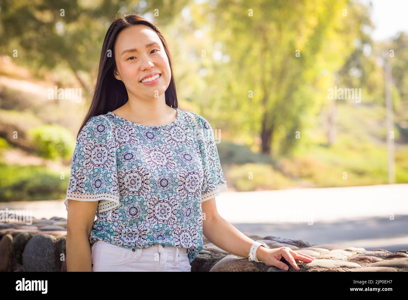 Außenportrait einer glücklichen chinesischen jungen erwachsenen Frau. Stockfoto