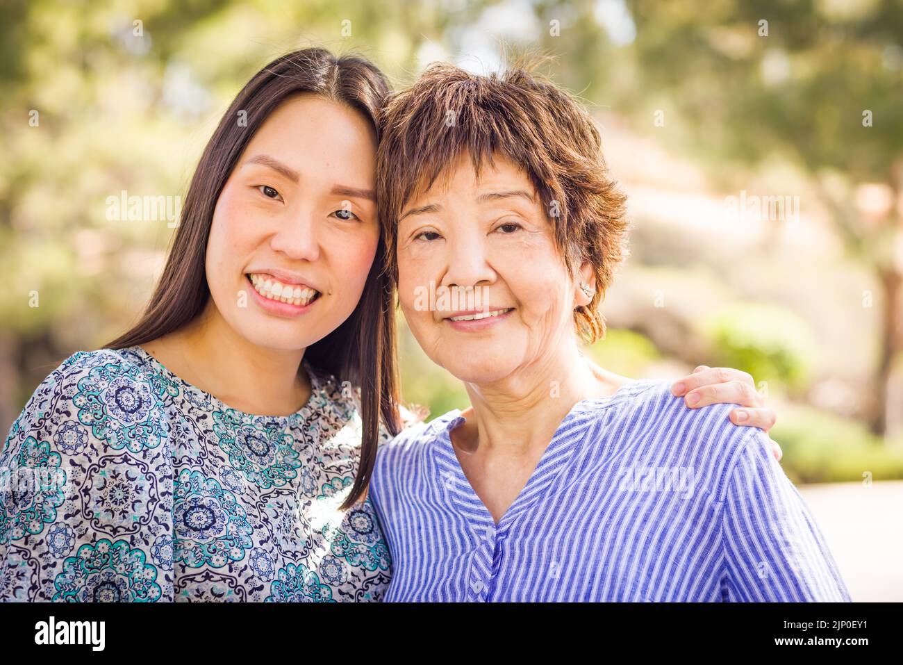 Außenportrait einer glücklichen chinesischen Mutter und Tochter. Stockfoto