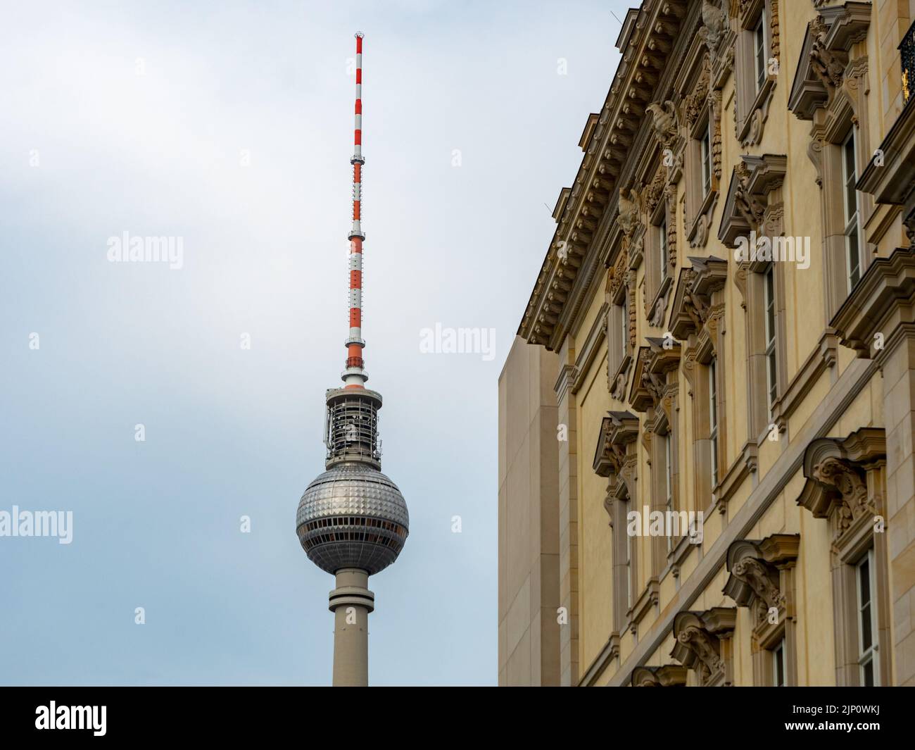 Berliner Fernsehturm neben einem alten Gebäude. Das berühmte Wahrzeichen der Hauptstadt Deutschlands. Außenansicht eines Reiseziels und einer Sehenswürdigkeit. Stockfoto