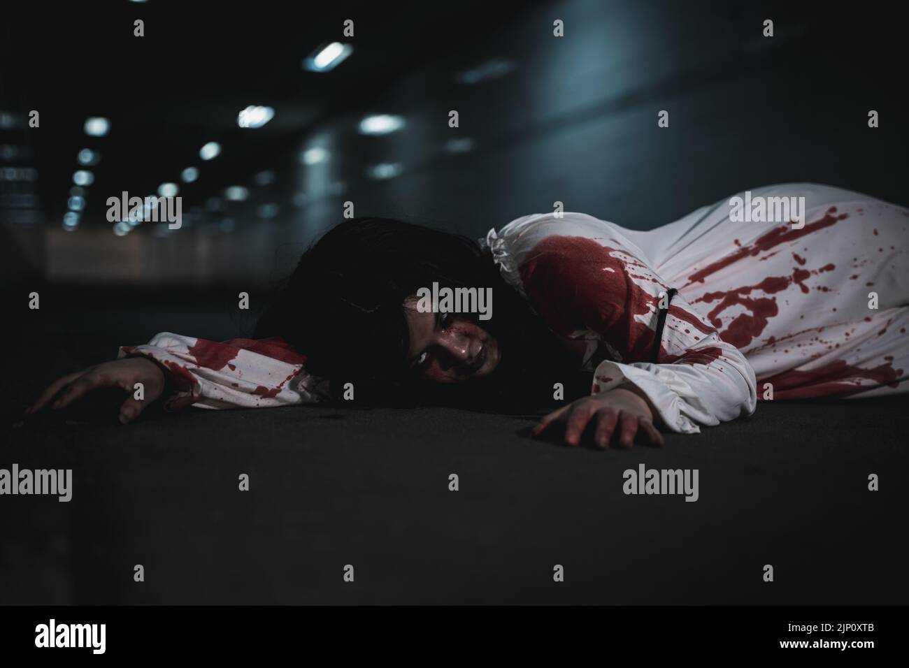 Horror blutrünstig Frau Geist Horror sie Tod und beängstigend in der dunklen Nacht im Tunnel, das Mädchen wurde von einem Auto getroffen und lag starb auf der Straße. Voller Bloo Stockfoto