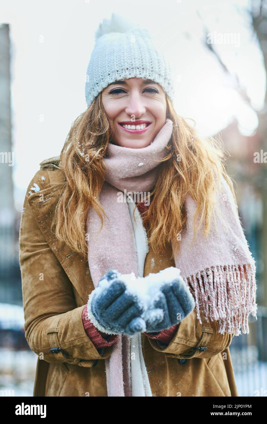 Schneeball macht Zeit. Porträt einer attraktiven jungen Frau, die gerne draußen im Schnee ist. Stockfoto