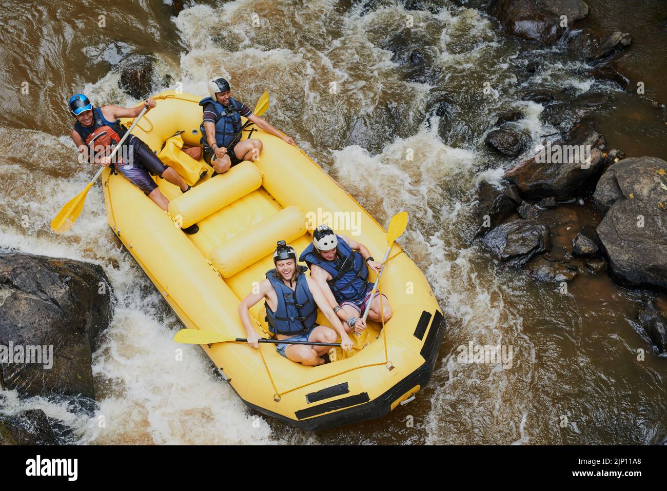 Stellen Sie sich auf, hier kommt die nächste schnelle. Eine Gruppe von jungen männlichen Freunden Wildwasser-Rafting. Stockfoto