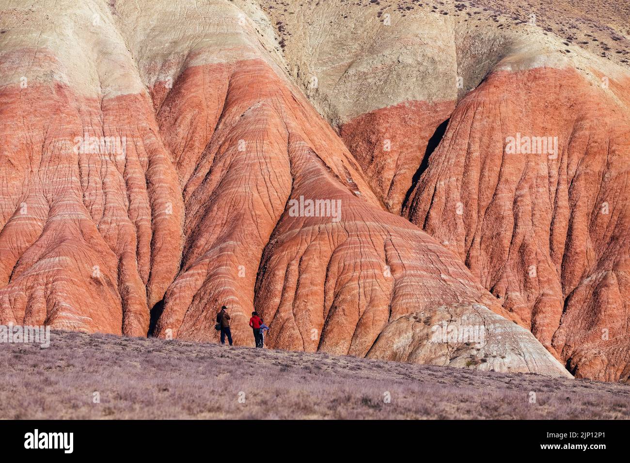 Die Menschen stehen an den schönen roten Bergen. Khizi-Region. Aserbaidschan. Stockfoto
