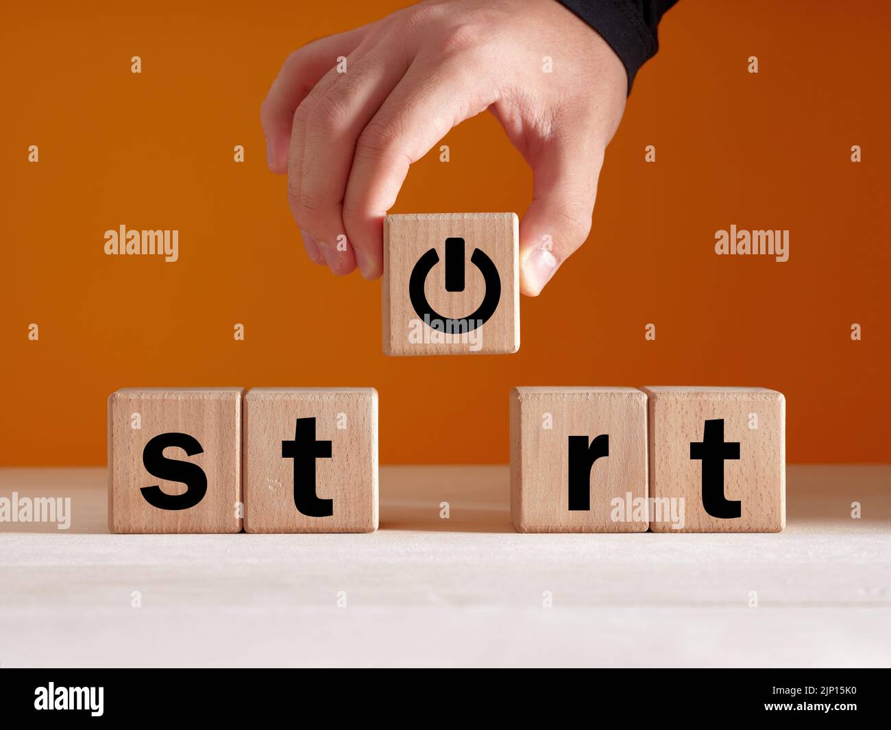 Einen neuen Start in das Leben, die Wirtschaft, Bildung oder Karriere Konzept zu machen. Hand legt einen Holzwürfel mit Start- oder ein-/aus-Taste. Stockfoto