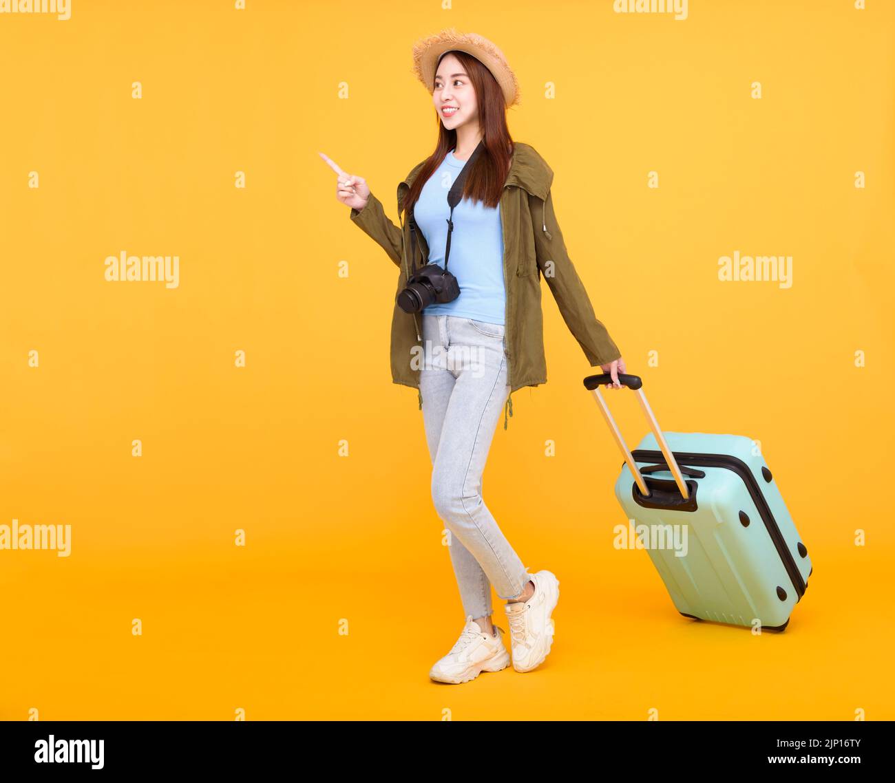 Glückliche junge Frau mit Gepäck und Kamera isoliert auf gelbem Hintergrund, Herbst, Reisekonzept. Stockfoto