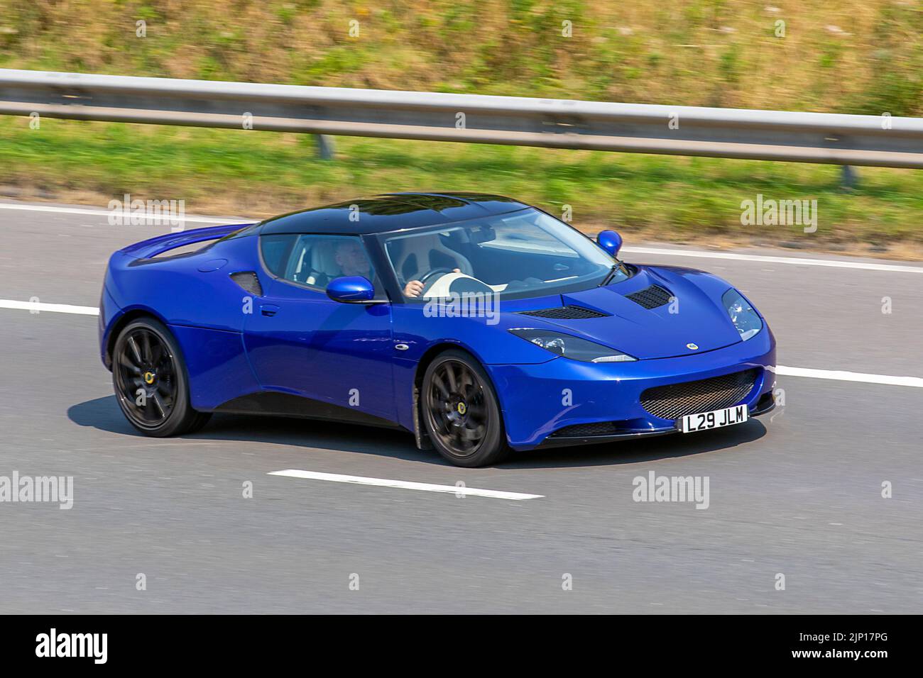 2010 blauer Lotus Evora 2 V6; fahrende Autos, gefahren, in Bewegung, unterwegs auf der Autobahn M6, Großbritannien Stockfoto