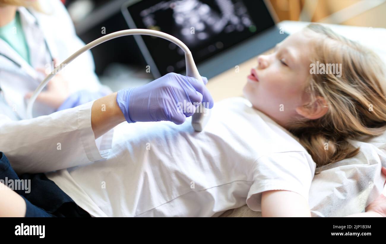 Arzt, der die diagnostischen Untersuchungen der inneren Organe bei Kindern mithilfe eines Ultraschallgeräts macht. Stockfoto