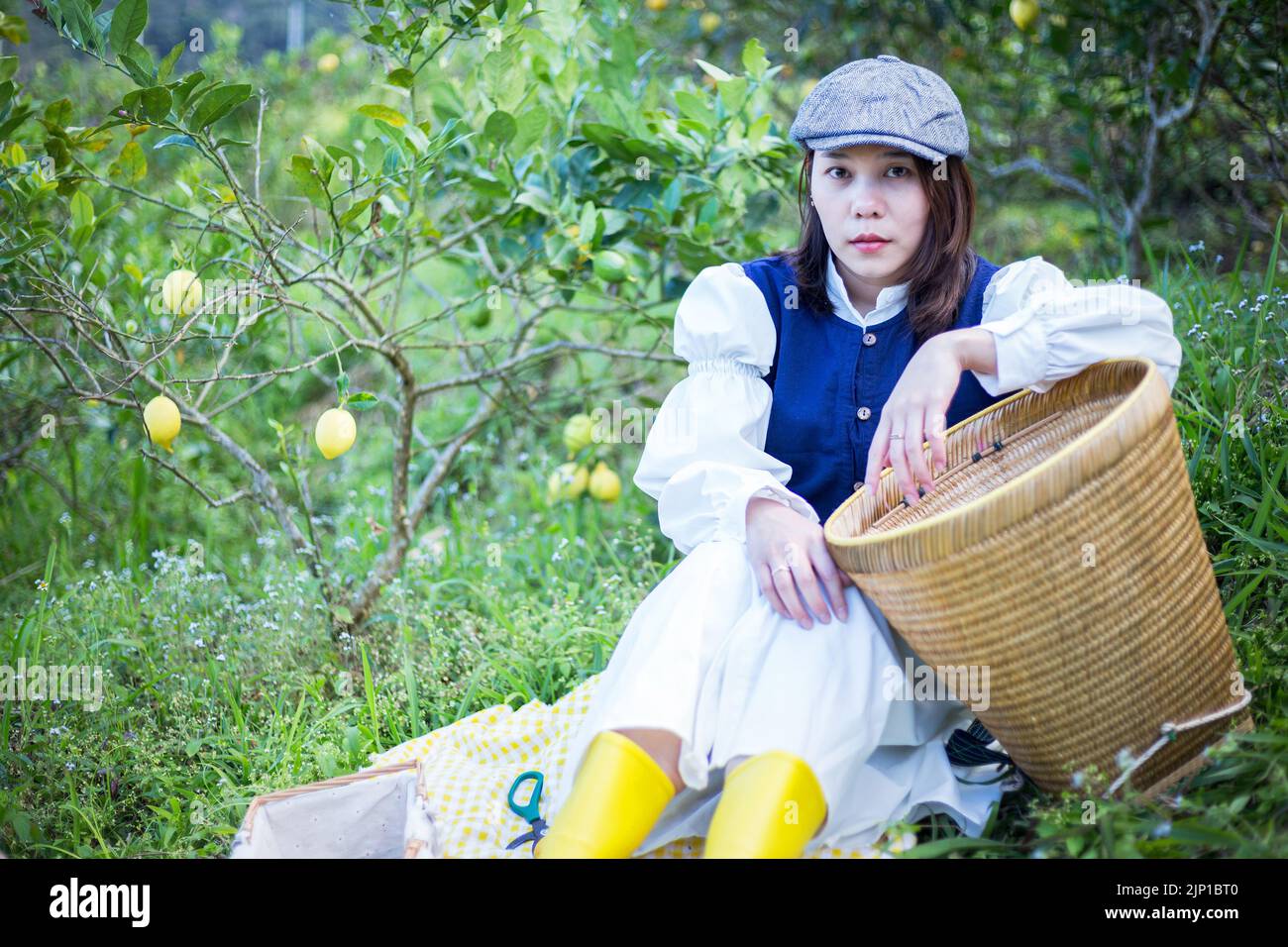 Asiatische Frau arbeiten und reisen in Zitronenfarm mit Bauernmode und Accessoires Stockfoto