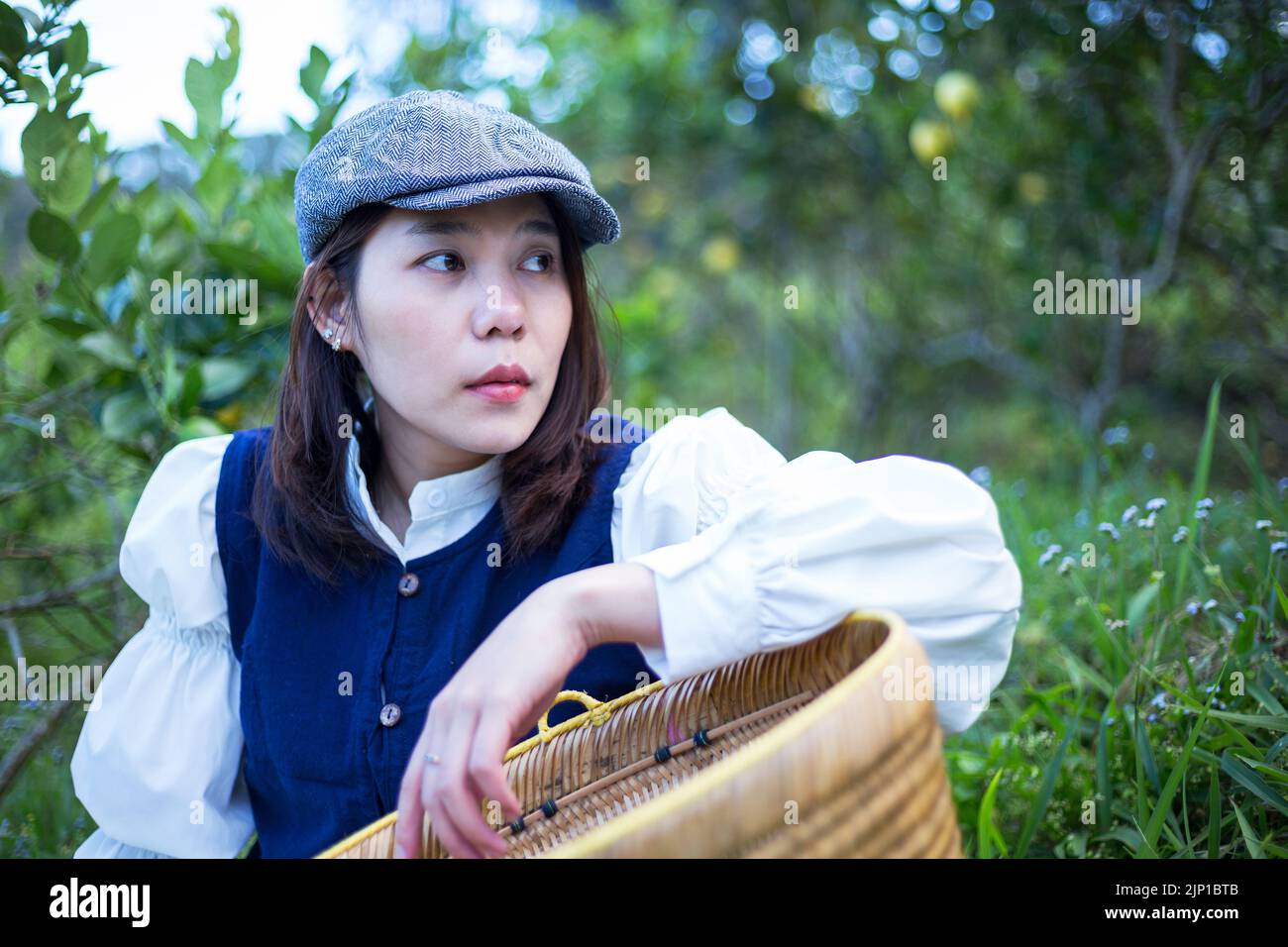 Asiatische Frau arbeiten und reisen in Zitronenfarm mit Bauernmode und Accessoires Stockfoto
