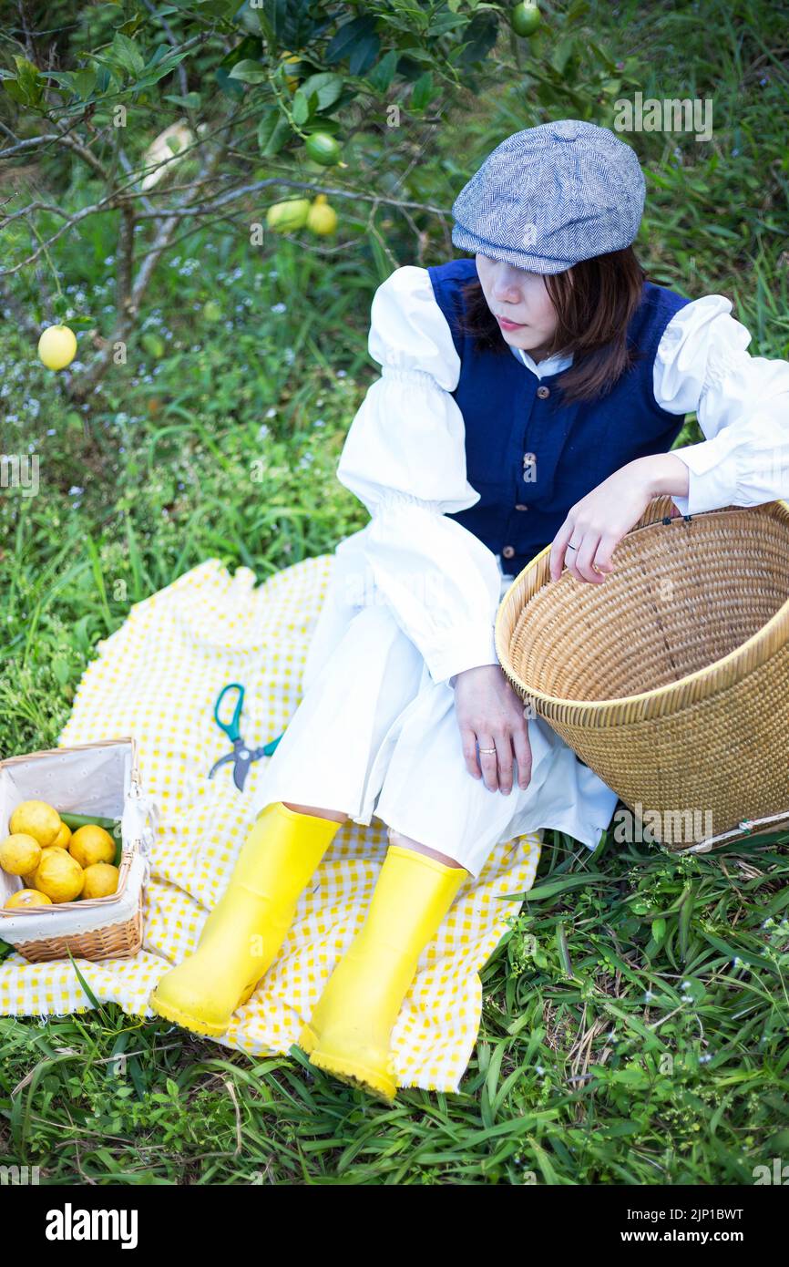 Asiatische Frau arbeiten und reisen in Zitronenfarm mit Bauernmode und Accessoires Stockfoto